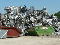 Green and red skips in front of scrap metal